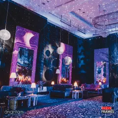 A wider view of the retro lounge seating. The space was dotted with moon-like spheres and disco balls, and the ceiling was lit to look like a starry sky, creating a cool, cosmic disco vibe.