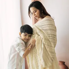 A son listens for his new sibling's heartbeat. These are the unscripted, precious moments that make a maternity session so special.