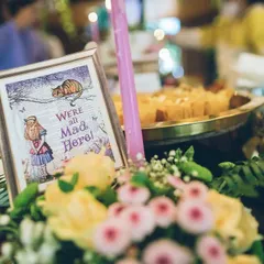 "We're all mad here." I use framed quotes and floral arrangements to create charming, on-theme centerpieces that bring the story of Alice in Wonderland to life on every table.
