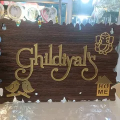 A rustic wooden nameplate with golden acrylic letters. This design for 'Gildiyal's Home' features cute birds and a Ganesha, adding a warm, welcoming touch.