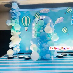 A charming hot air balloon theme in shades of blue and white. This stage setup includes a striped floor, a lighted archway backdrop, and balloon clouds to create a feeling of floating in the sky.