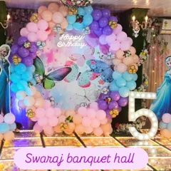 A magical Disney Princess theme for a 5th birthday party. The stage is decorated with a pastel balloon arch and cutouts of Cinderella, Ariel, and other princesses.
