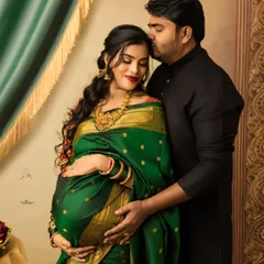 A tender moment captured during a twin pregnancy photoshoot. The husband's gentle kiss and the rich green silk saree create a portrait that is both intimate and regal, inspired by traditional Indian art.