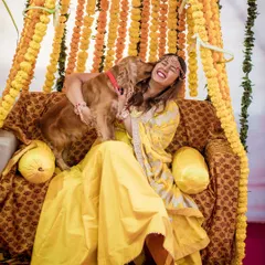 An exuberant moment of a bride getting showered with love from her dog during her Haldi. This photo captures the pure, unscripted joy that pets bring to any celebration.