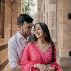 An intimate moment shared between the couple amidst the beautiful archways of South Mumbai. This candid pre-wedding portrait captures their genuine smiles and affection.