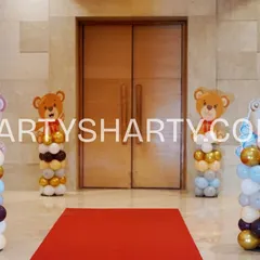 A simple yet adorable entrance with a red carpet flanked by four balloon columns, each topped with a different cute teddy bear cutout.