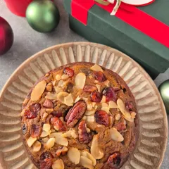 My traditional boozy Plum Cake for Christmas. It's rich, moist, and packed with rum-soaked fruits and nuts like pecans and almonds, presented in a festive gift box.