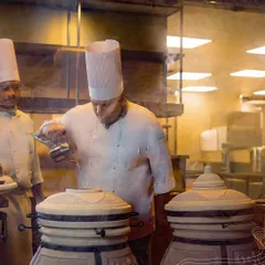 Our chefs working at traditional tandoors, showcasing the authentic cooking methods we use to achieve unparalleled flavor in our Indian dishes.