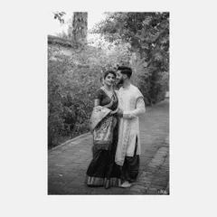 A classic black and white full-length portrait of a couple in traditional Marathi attire, walking along a garden path. This style of engagement portrait is timeless and elegant.