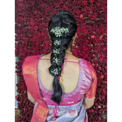 A close-up of a classic fishtail braid adorned with fresh flowers. This is a timeless hairstyle for traditional events, perfectly complementing a silk saree.