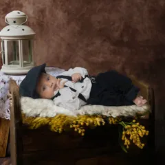 A vintage-style portrait of a baby boy dressed in a classic outfit with a newsboy cap. I use props like this antique-style lantern to add character to the photos.