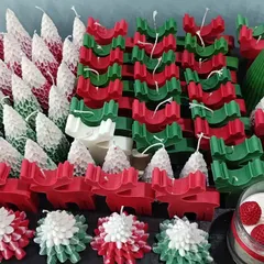 A festive collection of Christmas candles ready for the holiday season. This includes Christmas tree pillar candles, reindeer-shaped candles, and other decorative designs.