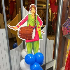 A traditional Punjabi dhol player cutout adds an authentic touch to the Lohri party decor.