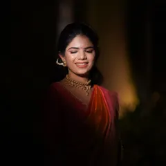 A dramatic bridal portrait using creative lighting techniques. The focused light highlights the bride's serene expression and beautiful features during her Haldi function.