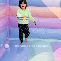 A happy girl holds a ball inside our pastel bounce house. The colorful, striped interior makes for a cheerful and engaging play environment.