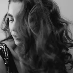 A close-up in the same monochrome series, highlighting the soft texture of the makeup and hair. The subtle shimmer on the eyelid catches the light beautifully.