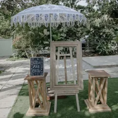We love adding personal touches like this rustic photo-op corner. A vintage wooden frame on an easel, a lace parasol, and a charming chalkboard sign create a dedicated spot for guests to capture memories.