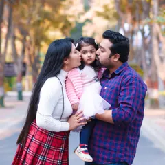 Kisses for the birthday girl. This heartwarming shot captures the love and affection of the family during an outdoor photoshoot.