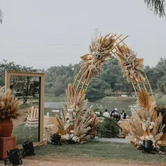 A stunning pampas grass archway for a lakeside anniversary celebration. The design is rustic, elegant, and perfectly complements the natural beauty of the sundowner setting.