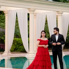 A portrait of pure elegance and style. The couple stands by the poolside, their formal attire creating a striking contrast with the serene, grand setting. This is modern glamour at its finest.