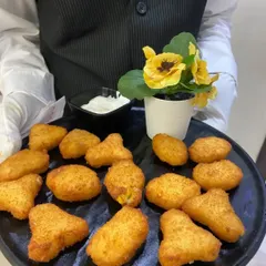 Our Cheese Corn Nuggets are a favorite among guests of all ages. These crispy, golden bites are filled with a creamy mixture of cheese and corn, served hot with a dipping sauce.