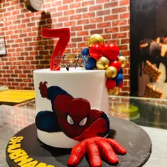 For the superhero fans, I design cakes that pack a punch. This Spiderman-themed birthday cake features a 3D fondant hand reaching out, making the action feel real. It's a popular choice for kids' birthday parties.
