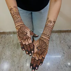 The peacock is a timeless symbol of grace and beauty in mehendi art. Here, I've made it the centerpiece of the design, with intricate feather details on the palm and geometric patterns extending up the wrist.