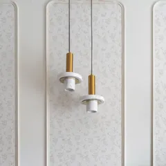 Detail of the pendant lights and wall treatment in the 'Flux Abode' master bedroom. The floral wallpaper inside the rounded rectangular moldings adds subtle texture.