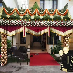 I love creating a grand welcome for your guests. This housewarming entrance arch combines traditional elements like banana trees and marigold garlands with unique pillars made of polished coconuts for a truly impressive first impression.