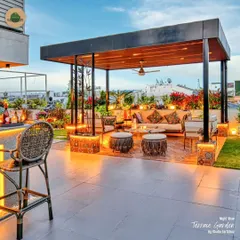 Your terrace can be the most beautiful room of your house. We designed this rooftop garden as a complete outdoor living area, with a stylish bar, comfortable lounge seating under a lit pergola, and lush floral beds that come alive at night.