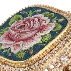 A detailed view of my handcrafted micromosaic rose ring. The pink rose is set against a deep teal background, framed by 18k gold and diamonds.