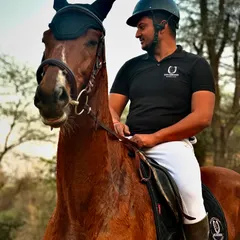 A rider, dressed in our club polo shirt, shares a proud moment with his horse. This is the look of a confident and accomplished equestrian.