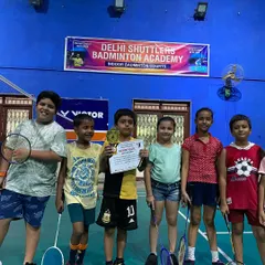 A group of our junior players celebrating a win at the academy. The player in the center holds his trophy and certificate, surrounded by his training partners.
