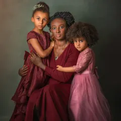 Motherhood is a masterpiece of emotions, and this portrait aims to capture its beautiful complexity. Here, a mother's protective embrace and her daughters' trusting gazes create a powerful, loving tableau reminiscent of a classic painting. It’s a celebration of the unbreakable bond between a mother and her children.