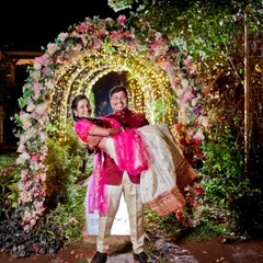 The groom lifts his bride in a stunning floral light tunnel. This is a great example of a night-time pre-wedding shoot that feels like a scene from a movie.