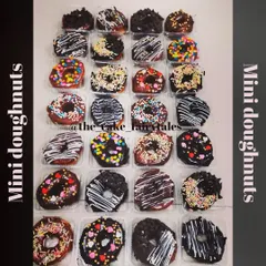 An overhead view of a large order of assorted mini donuts. I offer a wide variety of toppings so you can mix and match, including white chocolate drizzle, choco chips, and festive sprinkles.