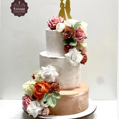 A grand 5kg three-tier cake for an engagement party. The design features a rustic textured finish in white and rose gold, adorned with a cascade of artificial flowers for a timeless and romantic feel.