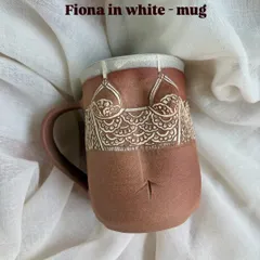 The 'Fiona' mug in white from the Déesse Collection. The design is softer, reflecting a different personality, but with the same attention to hand-carved detail that defines these pieces.