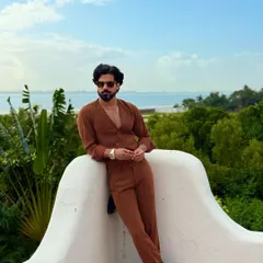 A relaxed pose against a stunning ocean backdrop, this image captures the essence of sophisticated resort wear.