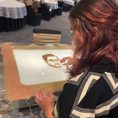 A candid shot of me creating a portrait during the live sand art show for Jay Shree Tea. Every performance is a deep dive into the client's history and achievements.