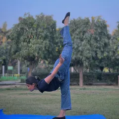 Practicing a standing split in the park. The fresh air and open space in Model Town add a special energy to our yoga sessions.