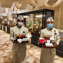 Our professional service team is the backbone of every flawless event. Dressed in sharp, elegant uniforms, they ensure every guest feels attended to, here seen serving appetizers before a grand wedding buffet.