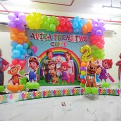 A full Cocomelon themed decoration for a second birthday party, perfect for toddlers. This setup includes a large, colorful backdrop with the entire Cocomelon family and friends, framed by a vibrant balloon garland. Life-sized character cutouts of JJ, TomTom, YoYo, and their animal friends bring the theme to life, making it an immersive experience for the little ones.