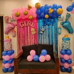 A fun setup for a gender reveal party. I created a split backdrop with pink and blue fringe curtains and balloons, with 'GIRL' and 'BOY' signs, letting everyone guess before the big reveal.