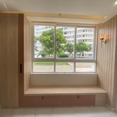 We love creating cozy corners like this window seat. It's the perfect spot to read a book or enjoy a cup of tea, with built-in storage drawers underneath and a stylish wall sconce for lighting.