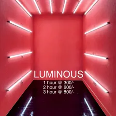 Welcome to the 'Luminous' booth. This room features vibrant pink walls and is framed by horizontal white tube lights on all sides, creating an immersive box of light. The rental prices are listed for this popular and eye-catching reel-making space.