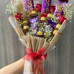 You can never go wrong with chocolates and flowers. This is our deluxe chocolate bouquet, featuring a mix of Dairy Milk and Ferrero Rocher chocolates nestled among fresh red roses and baby's breath.