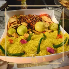 Our creative presentation of Bhel Puri. We assemble fresh ingredients like puffed rice, sev, peanuts, and chopped vegetables in an attractive display, ready to be mixed into a delicious and tangy snack for your guests.