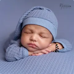 The classic 'chin on hands' pose is a favorite for showing off a newborn's chubby cheeks and peaceful expression. I achieve this pose gently and patiently, always following the baby's lead.