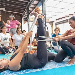 Partner work is a key element in my workshops. Here, one student helps another in Supta Padangusthasana, using a belt to gently increase the hamstring stretch while ensuring the pelvis remains stable. This fosters a sense of collaboration and shared learning.